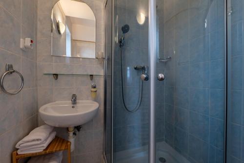 a bathroom with a sink and a shower at Penzion Fortuna in Liptovský Mikuláš