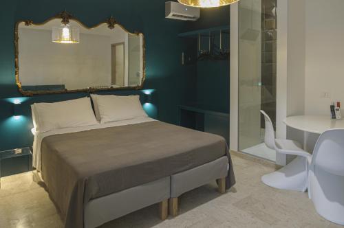 a bedroom with a bed with a mirror and a table at B&B Sbarco dei 1000 Marsala in Marsala