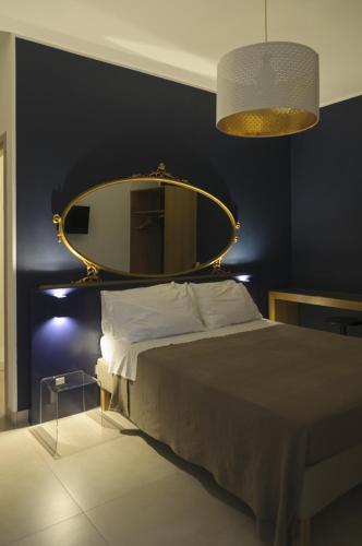 a bedroom with a bed with a mirror on the wall at B&B Sbarco dei 1000 Marsala in Marsala