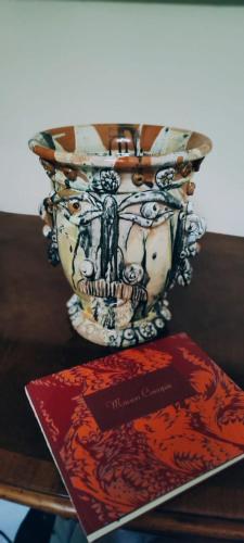 a vase sitting on a table next to a book at Maison Canopée in Messina