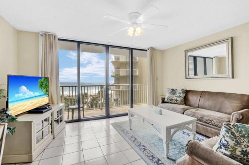 a living room with a couch and a tv at Seaside Beach 5415- direct beach front pools sauna in Orange Beach