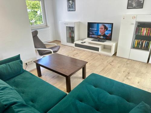 a living room with a couch and a tv at Wohnen auf Zeit - Biebesheim in Biebesheim