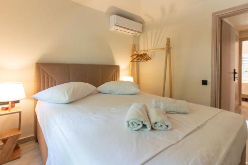 a bedroom with a white bed with towels on it at Villa Eden in Iraklitsa