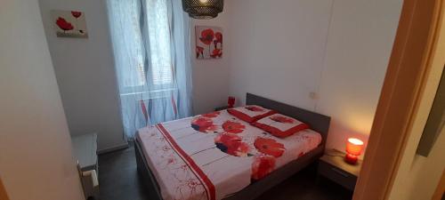 Cette petite chambre comprend un lit avec des draps rouges. dans l'établissement valsappart, à Vals-les-Bains