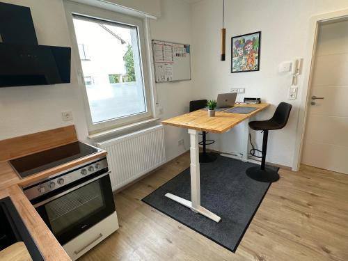 a small kitchen with a table and a desk at Wohnen auf Zeit - Biebesheim in Biebesheim
