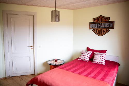 a bedroom with a bed with a red comforter at Muhu Kulla Saadu puhkemaja mere ääres in Raugi
