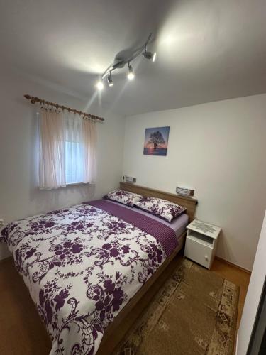 スヴェティ・マルティン・ナ・ムリにあるKuca za odmor Mareのベッドルーム1室(紫と白の掛け布団付きのベッド1台付)