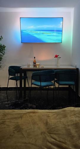 a table with two chairs and a television hanging on a wall at Studio Kamarin in Buzdohanj