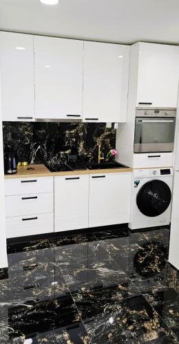 a kitchen with white cabinets and a microwave at Studio Kamarin in Buzdohanj