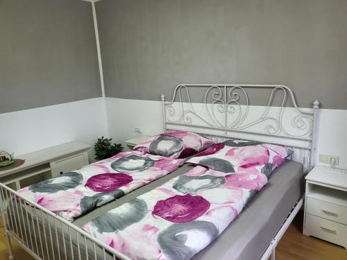 une chambre avec un lit avec des draps roses et gris dans l'établissement Ferienwohnung Mosel Hunsrück, à Moritzheim