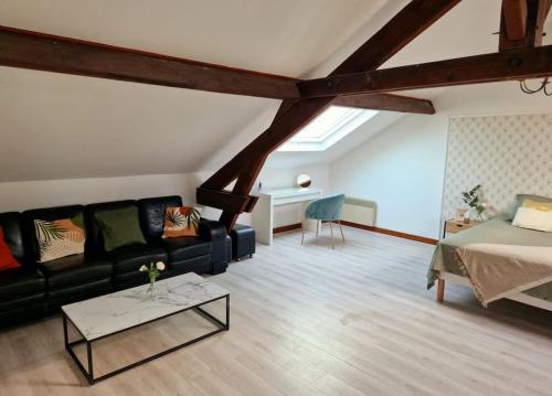 un salon avec un canapé noir et une table dans l'établissement Grande maison en Bords de Marne - 25 min de Paris, à Créteil