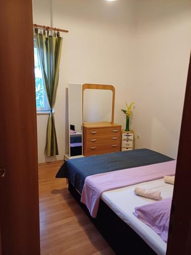 a bedroom with a bed and a dresser and a mirror at Apartment K&M in Senj