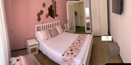 a bedroom with a large white bed with pink walls at Casa Lavi Rapallo in Rapallo