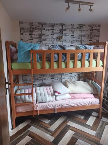 2 Etagenbetten in einem Zimmer mit einer Wand in der Unterkunft Betlejem Domek nad Jeziorem in Gostyczyn