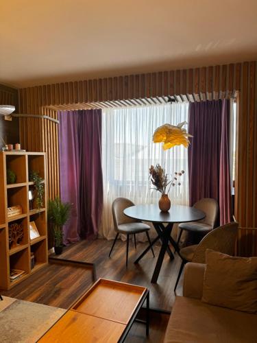 ein Wohnzimmer mit einem Tisch und einem Fenster in der Unterkunft Lovely 2 Rooms apartment in the CENTER of the city in Bukarest