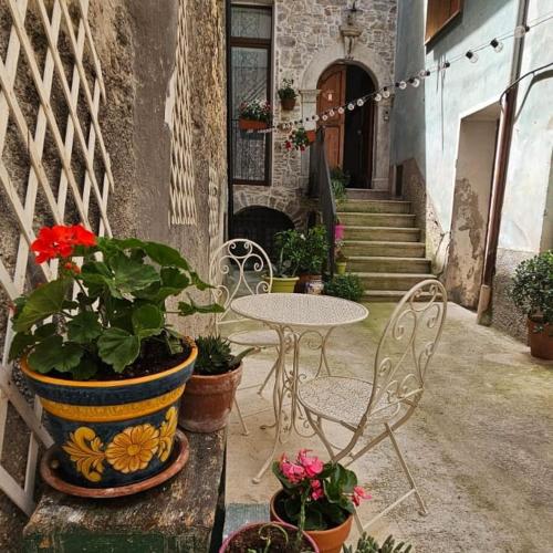 a patio with a table and chairs and potted plants at Nel Borgo di San Francesco - Casa vacanze in centro in Villa Santa Maria