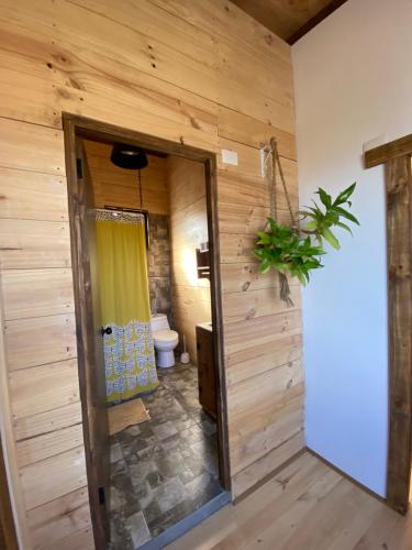 a bathroom with wooden walls and a toilet at Cabaña Zen Camino al cristal con la mejor vista desde lo alto a bahía de Pichidangui in Los Vilos