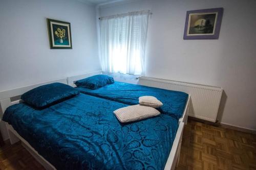 Una cama con sábanas azules y almohadas en un dormitorio en Kuća za odmor 204 jezero Šoderica en Legrad