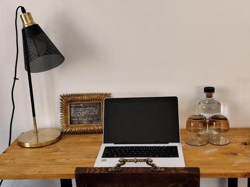 un ordenador portátil sobre un escritorio de madera en stressfree charm house en Odeceixe