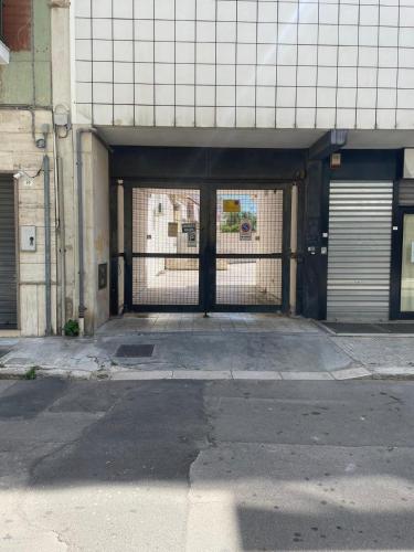 an empty parking lot with a gate in a building at Maison Patricia in Lecce