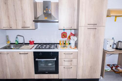 uma cozinha com armários de madeira e um forno com placa de fogão em Al Manzil em Locogrande