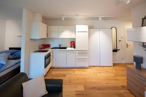 a kitchen with white cabinets and a bed in a room at Ferienwohnungen - barrierefrei - im sanierten Gutshof in Lalendorf