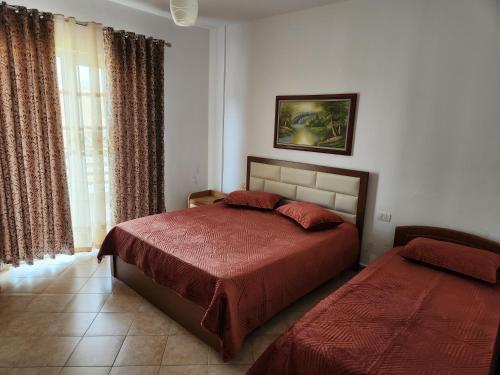 1 dormitorio con 2 camas y ventana en Comfy Beachfront Apartment - 50m from the Sea, en Golem