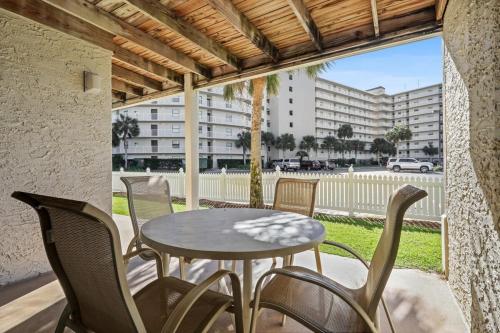 a patio with a table and chairs and a building at Seaside Beach 2103- Ground level beachside in Orange Beach