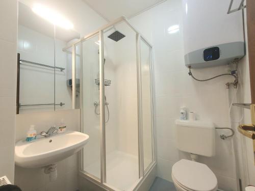 a bathroom with a shower and a toilet and a sink at Beach & Wellness Apartman Siófok in Siófok