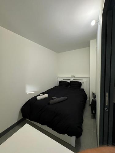 - une chambre blanche avec un lit noir dans l'établissement Très bel appartement, à Cannes