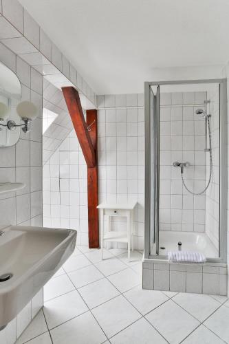 a white bathroom with a shower and a sink at Hotel & Pension Villa Camenz in Güstrow