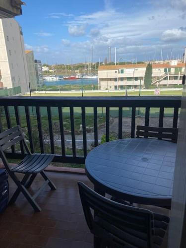 d'une table bleue et de chaises sur un balcon avec vue. dans l'établissement Charmant studio île des pêcheurs piscine tennis, au Cap d'Agde