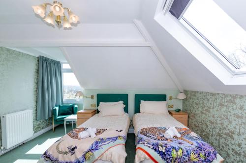 a bedroom with two beds in a attic at Phoenix Rise Retreat in Glastonbury