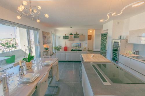 une grande cuisine avec une table à manger et un salon dans l'établissement Appartement 90m2-Roof Top privé 100m2-Parking privé-Clim mobile, à Nantes