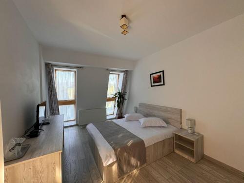a bedroom with a bed and a television in it at Pensiunea Agroturistică Magdalina in Vatra Dornei