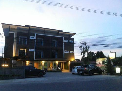 a building with two cars parked in front of it at Bansappoori in Lamphun