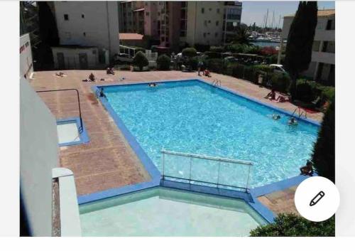 une grande piscine bleue avec des gens dedans dans l'établissement studio charmant sur île des pêcheurs résidence piscine tennis, au Cap d'Agde