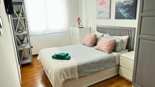 ア・コルーニャにあるCalle Barrera. En el centro!のピンクの枕が付くベッドが備わる小さなベッドルーム1室