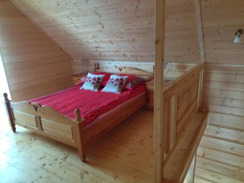 um quarto com uma cama num chalé de madeira em Gładyszówka - Chatka w Gorcach em Ponice