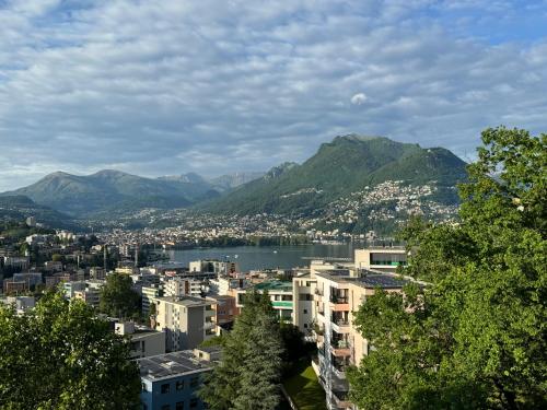 a city with a lake and mountains in the background at Panorama Suite in Lugano - Pazzallo in Paradiso