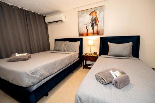 una camera con due letti e un tavolo con una lampada di Charming Retreat with Patio Access and FREE Laundry a Ponce