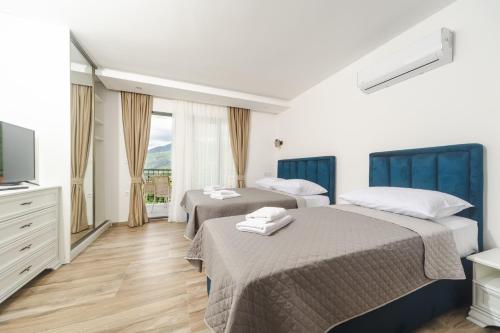 a hotel room with two beds and a television at Resort Bevilacqua in Budva