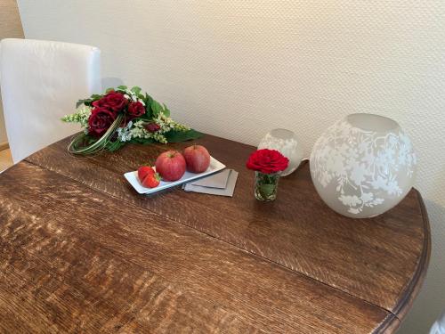 a table with flowers and apples and a vase on it at Haus Dürresbach in Hennef