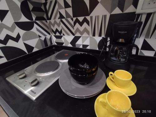 a counter with cups and saucers and a coffee maker at Victoria in La Marsa