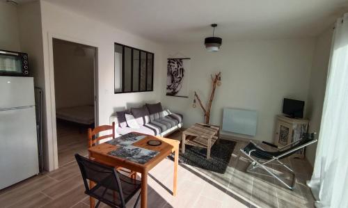 un salon avec un canapé et une table dans l'établissement Maisonnette indépendante, à Montroy