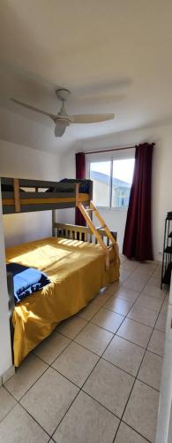 a bedroom with two bunk beds and a window at Maison Calme aux Avirons in Les Avirons