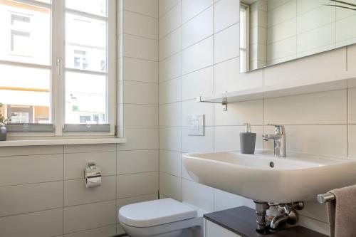 a white bathroom with a sink and a toilet at Ein gemütliches Studio mit Netflix im Zentrum Bahnhofsnähe in Coburg