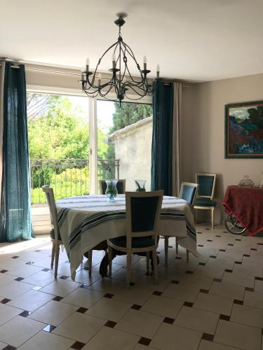 une salle à manger avec une table et des chaises et une fenêtre dans l'établissement Thebertisa, à Valréas