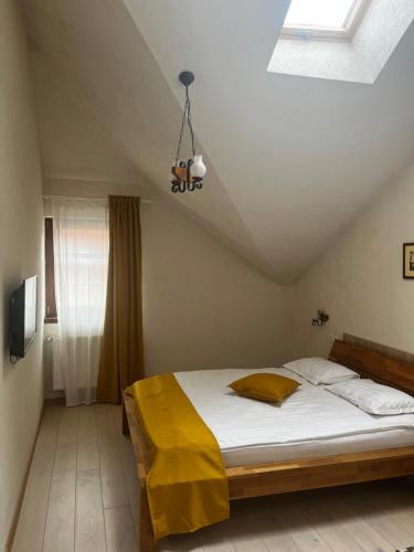 Cozy Apartment في براشوف: غرفة نوم بسرير وبطانية صفراء