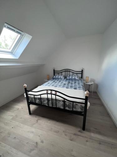 une chambre avec un lit dans une pièce avec une fenêtre dans l'établissement La maison de l'étang, à Vierzon